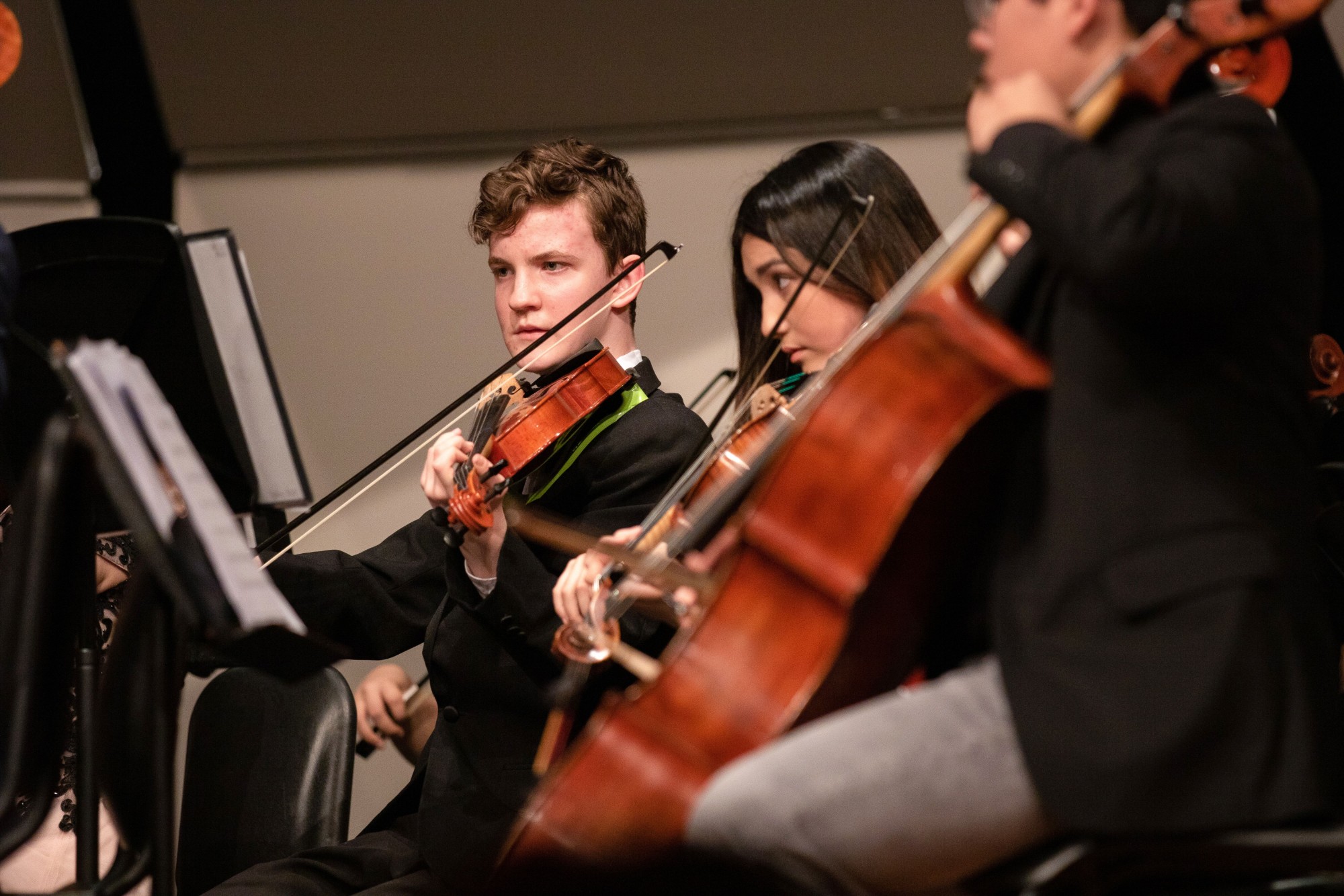 Students playing violin and cello together in an ensemble